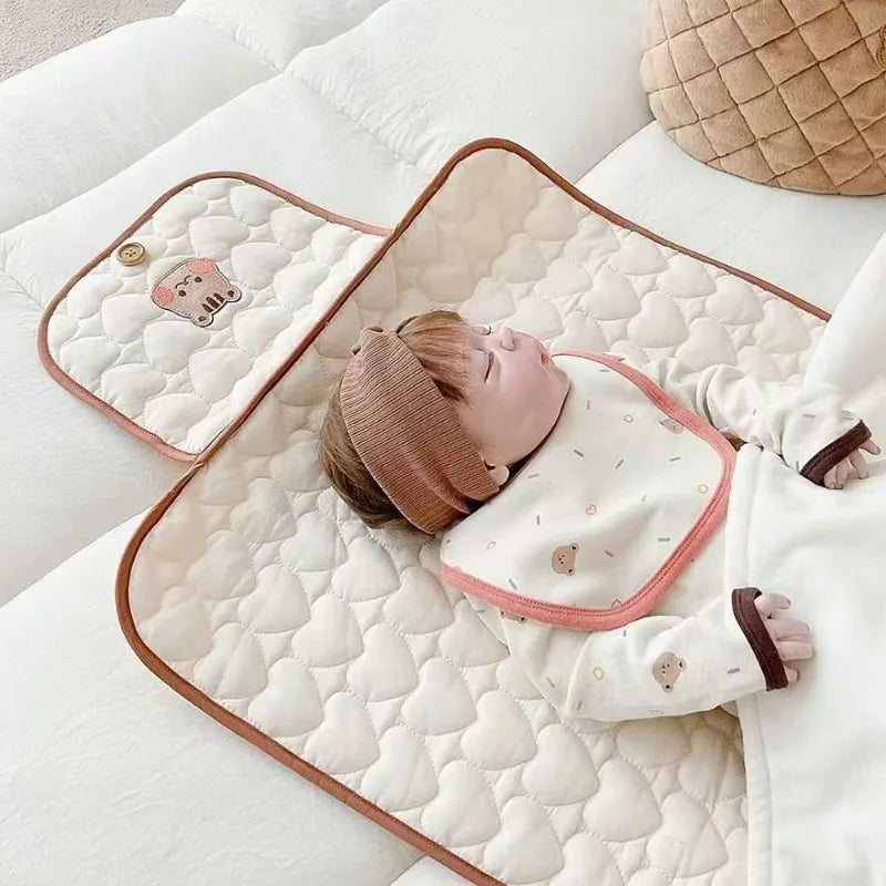 Matelas nomade à langer avec bébé qui dort