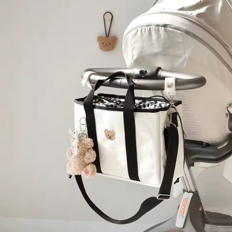 Sac a langer imperméable noir suspendu à une poussette