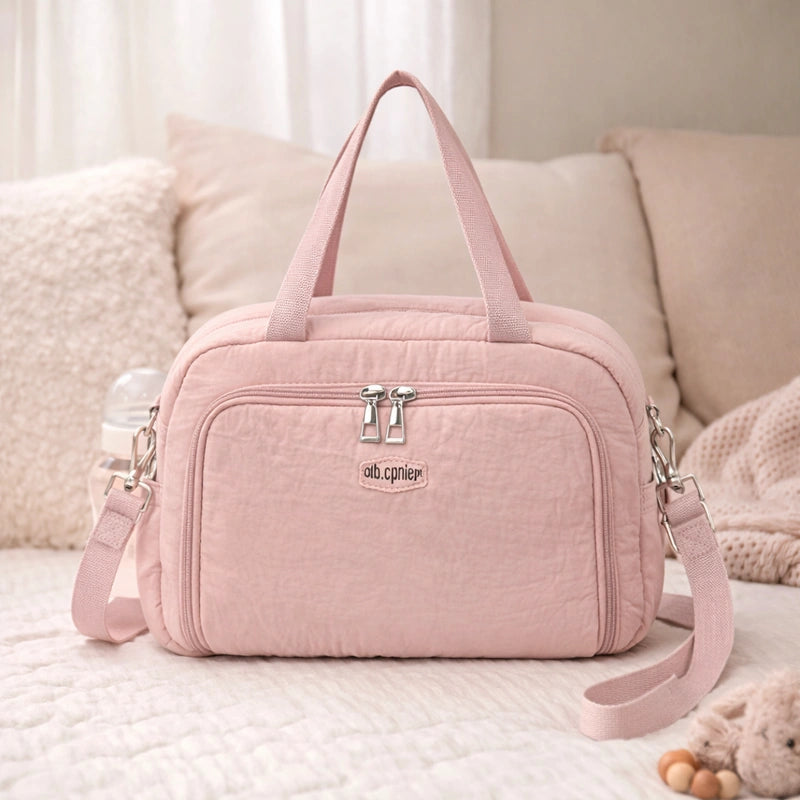 Sac à langer rose poudré​ sur canapé