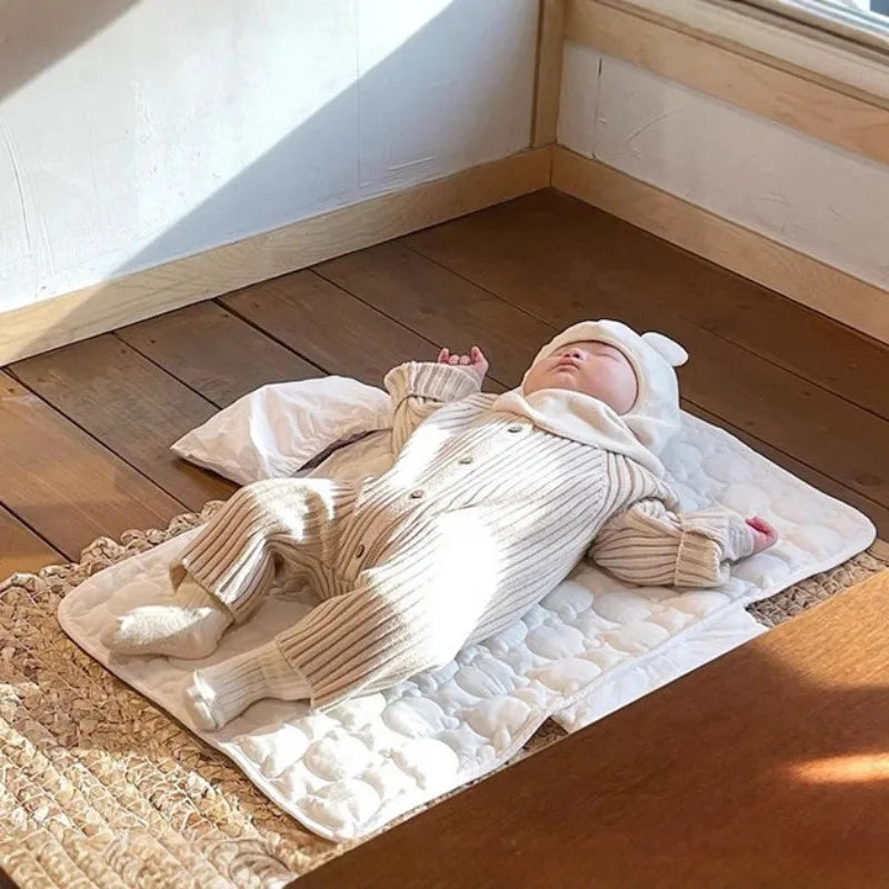 Bébé allongé sur tapis à langer nomade