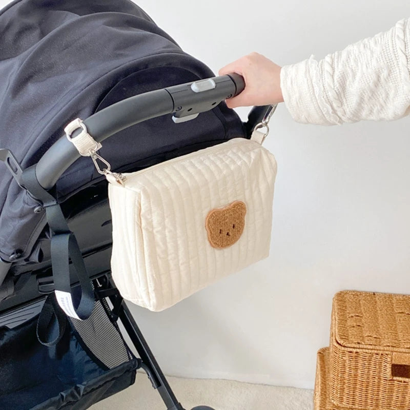 Petit sac à langer bébé accroché à une poussette